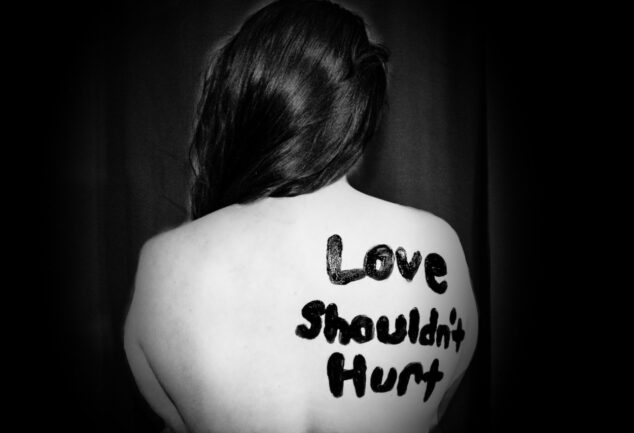 love shouldn't hurt-printed on back of woman