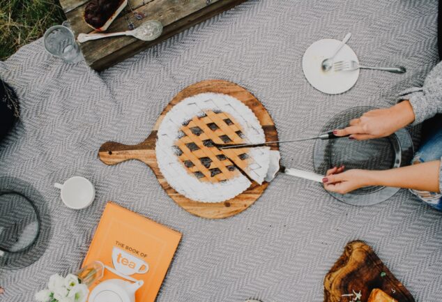 person holding a knife slicing a cake